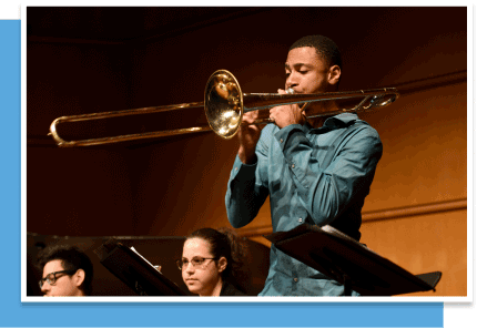 a young black man plays the trombone